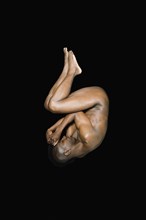 Nude African man in fetal position