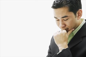 Asian man resting chin on fist