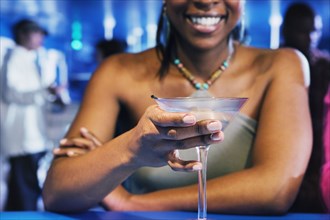 African woman holding cocktail