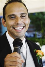 Russian man in tuxedo holding microphone