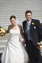 Multi-ethnic bride and groom holding hands