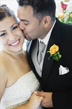 Multi-ethnic bride and groom kissing