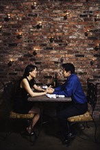 Asian couple holding hands at restaurant