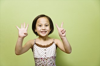 Asian girl holding up six fingers
