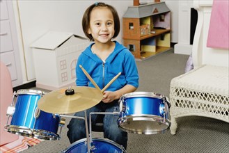 Asian girl playing drums