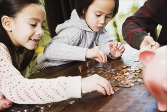 Asian siblings counting coins
