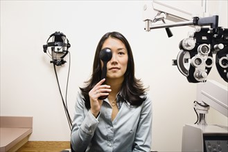 Asian woman taking eye exam