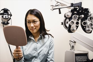 Asian woman trying on eyeglasses