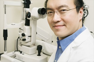 Asian male optometrist with equipment