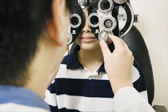 Asian male optometrist examining patient