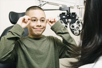 Asian boy trying on eyeglasses