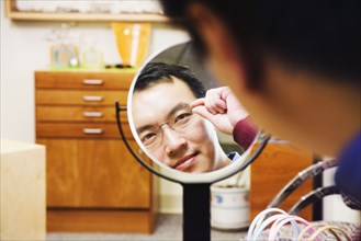 Asian man trying on eyeglasses