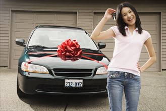 Asian teenager with keys to new car