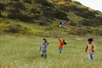 Friends flying kite in rural field