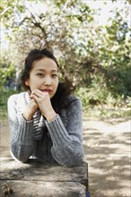 Asian woman sitting at picnic bench