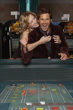 Woman hugging her successful boyfriend at a casino