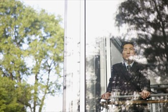 Asian businessman looking through window
