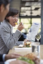 Hispanic businesswoman eating at restaurant