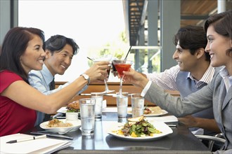 Multi-ethnic friends toasting at restaurant