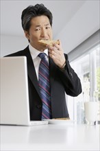 Asian businessman eating toast