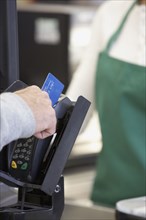 Man swiping credit card at grocery store checkout