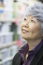 Senior Asian woman looking up