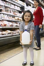 Indian girl carrying milk in grocery store