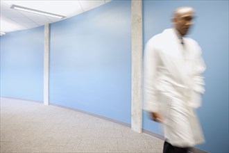 Mixed race doctor rushing in hospital hallway