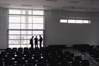 Business people talking in empty auditorium