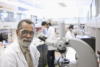 African American scientist using microscope in laboratory