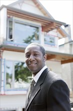 Black real estate agent near house under construction