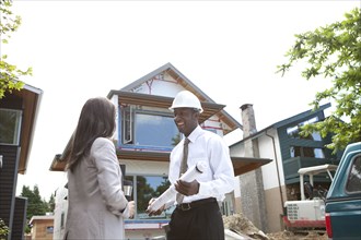 Real estate agents near house under construction