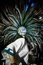 Dancer wearing feather headdress in performance