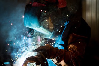Worker welding in workshop