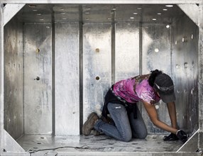 Worker examining metal walls