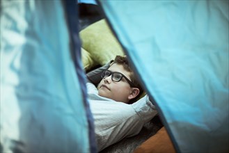 Hispanic boy camping in tent