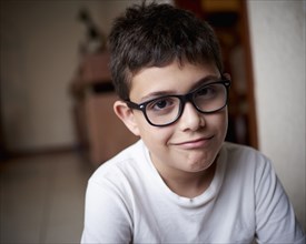 Smirking Hispanic boy wearing eyeglasses