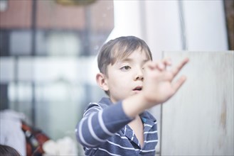 Hispanic boy touching window