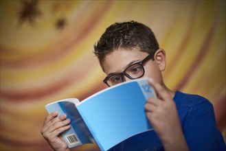 Hispanic boy reading blue book