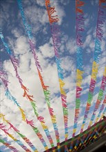 Multicolor flags blowing in wind under blue sky