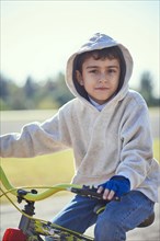 Hispanic boy posing on bicycle