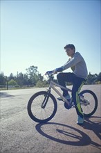 Serious Hispanic boy on bicycle