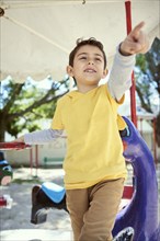 Hispanic boy on carousel at playground