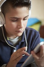 Hispanic boy using digital tablet and headphones
