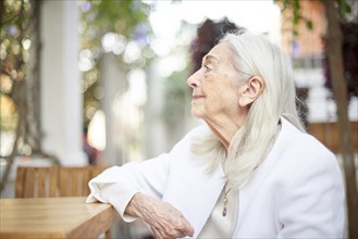 Profile of smiling older Caucasian woman sitting at table