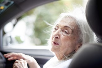 Older Caucasian woman sitting in car