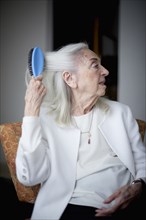 Older Caucasian woman brushing hair