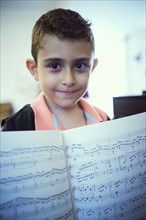 Hispanic boy showing sheet music