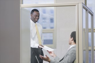 Multi-ethnic businessmen holding paperwork in office