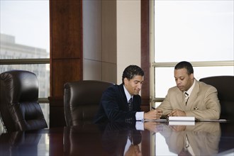 Two businessmen working in executive conference room